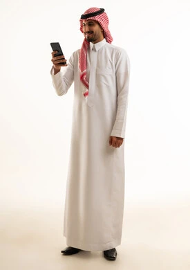 Saudi Man in Traditional Thobe Using Smartphone Studio
