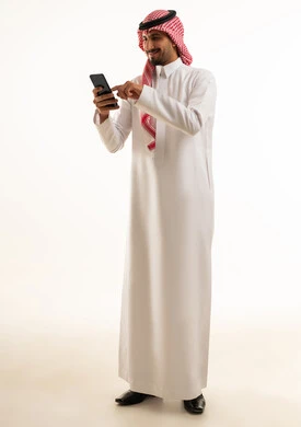 Saudi Man in Traditional Thobe Using Smartphone