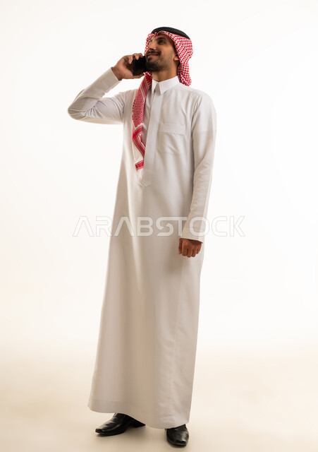 Saudi Man in Traditional Thobe Talking on Mobile Phone