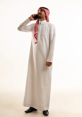 Saudi Man in Traditional Thobe Talking on Mobile Phone