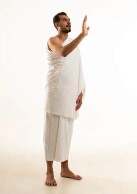 رجل سعودي بملابس الإحرام يقوم بإيماءة يد