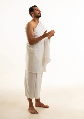 رجل سعودي بملابس الإحرام في وضعية الدعاء