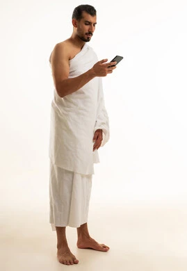Saudi Man in Ihram Using Smartphone on White Background