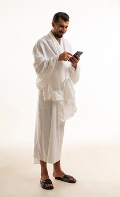 Saudi Man in Ihram Using Smartphone on White Background