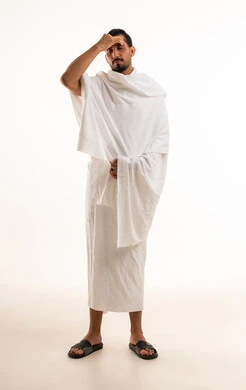 رجل سعودي بملابس الإحرام يشعر بالتعب والإرهاق