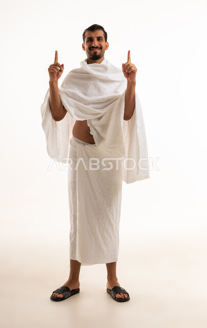 رجل سعودي بملابس الإحرام يشير للأعلى