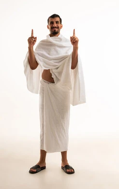 رجل سعودي بملابس الإحرام يشير للأعلى