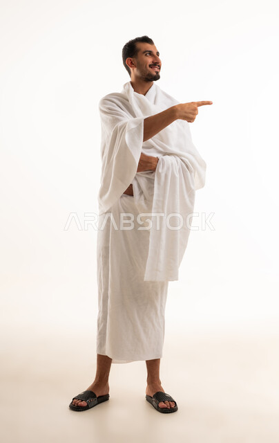 رجل سعودي بملابس الإحرام يشير للجانب في الاستوديو