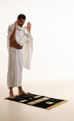Saudi Man in Ihram Standing on Prayer Rug