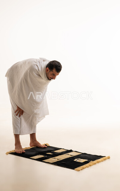 رجل سعودي بملابس الإحرام يؤدي الركوع