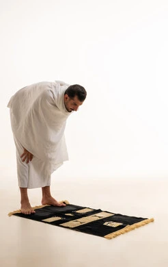 رجل سعودي بملابس الإحرام يؤدي الركوع