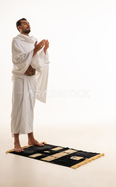 Saudi Man in Ihram Praying on Rug White Background