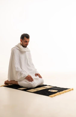 Muslim Man in Ihram Praying on Mat White Background
