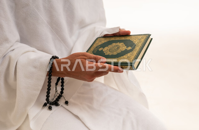رجل سعودي بملابس الإحرام يمسك المصحف والسبحة