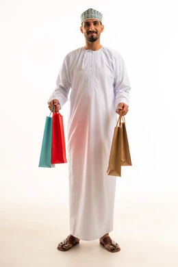 رجل عماني يحمل أكياس تسوق بخلفية بيضاء