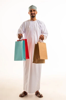 Omani Man in Traditional Dress Holding Shopping Bags