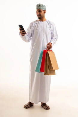 Omani Man with Shopping Bags Using Smartphone on White