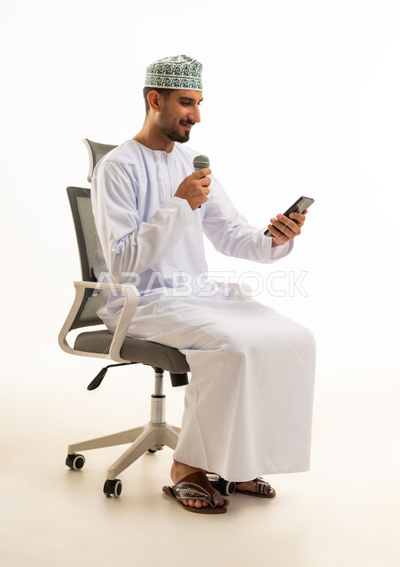 Omani Man with Microphone and Phone on White Background
