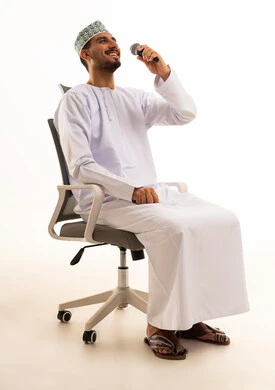 Omani Man with Microphone on Office Chair Studio Shot