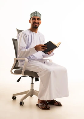 Smiling Omani Man Holding Book on Office Chair