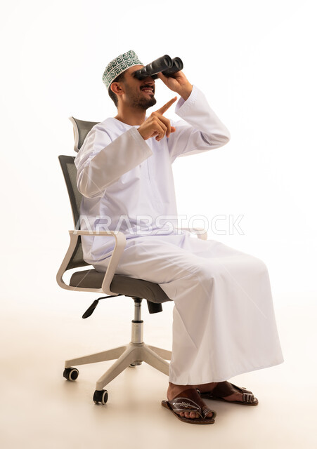 رجل عماني يستخدم المنظار على كرسي مكتب
