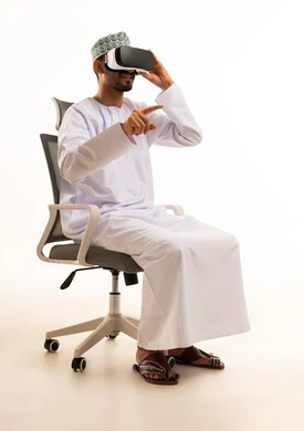 Omani Man Using VR Headset in Traditional Clothing