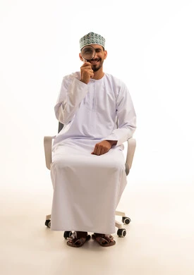 رجل عماني يحمل عدسة مكبرة بخلفية بيضاء