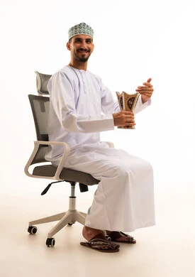 رجل عماني بالزي التقليدي يحمل مبخرة خشبية