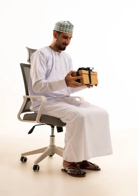 Omani Man in Traditional Dress Holding Gift Box