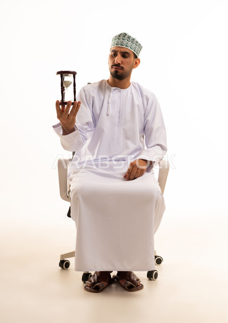 Omani Man Holding Hourglass in Office Chair White Background
