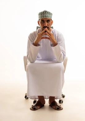 رجل عماني بالزي التقليدي في وضعية تفكير