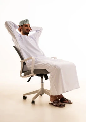 Omani Man in Traditional Dress Relaxing in Office Chair