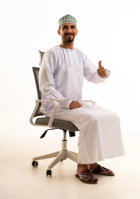 رجل عماني بالزي التقليدي يشير بعلامة الإعجاب