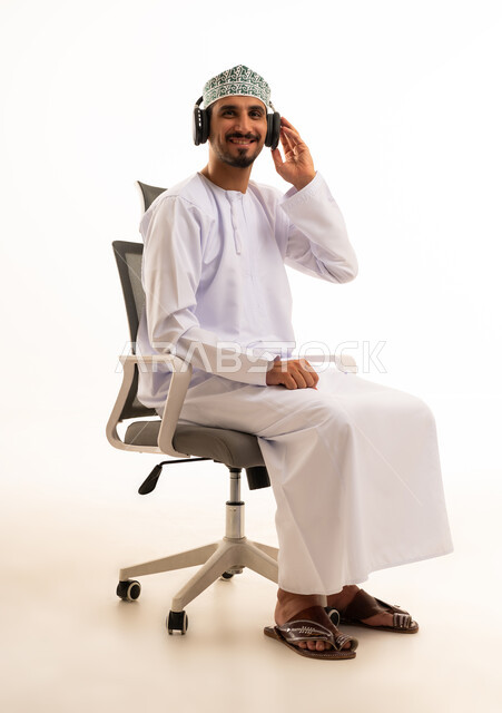 رجل عماني يرتدي سماعات على خلفية بيضاء