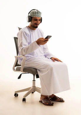 Omani Man with Headphones and Smartphone in Office Chair