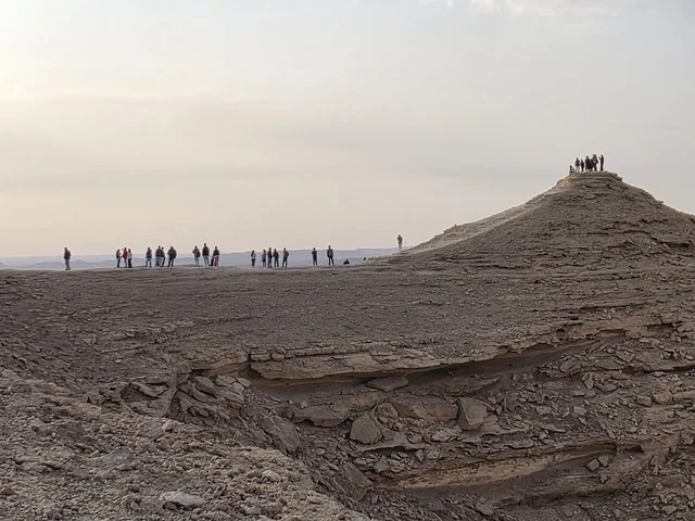 A massive mountain range, overlooking the Grand Canyon, a natural view of the edge of the world, the Tuwaiq Mountains in Riyadh, mountains in Najd in the Kingdom of Saudi Arabia, desert areas, rocky mountains and highlands, rocky peaks, historical landmarks, tourism in Saudi Arabia.