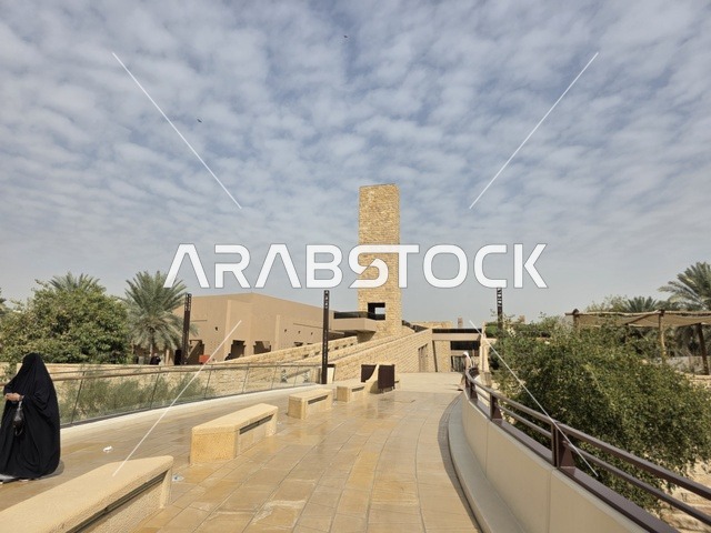 The old walls of Diriyah in the city of Riyadh, Saudi Arabia, are ancient historical archaeological landmarks, showcasing old architectural engineering art. A picture of the archaeological buildings and mud houses in the Al-Turaif neighborhood in Diriyah, with green palm trees, represents the heritage tourism areas in Saudi Arabia.
