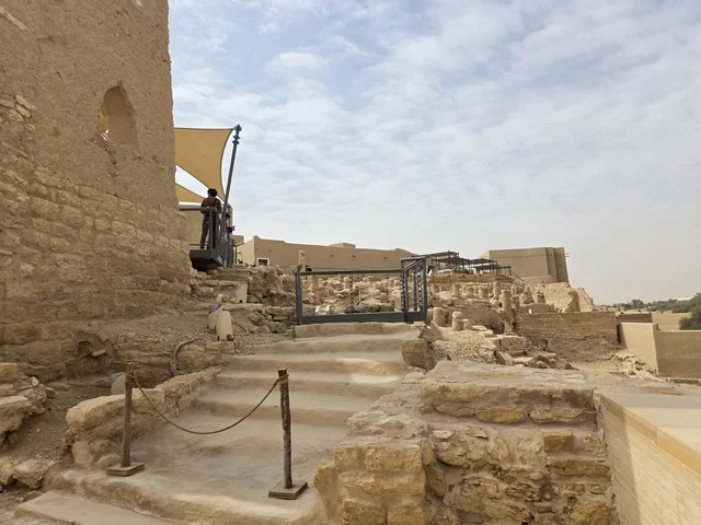 Ancient historical archaeological landmarks, the ancient architectural engineering art of the walls of Al-Salwah Palace in Al-Bujairi in Riyadh, a picture of the archaeological buildings and mud houses in Al-Turaif neighborhood in Diriyah, green palm trees, heritage tourism areas in Saudi Arabia.