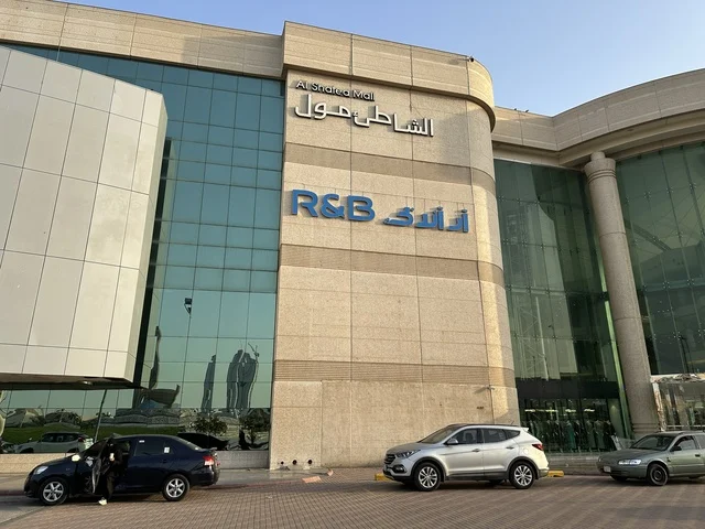 Traffic of cars in front of the entrance of the Beach Mall in Dammam, Eastern Province, Saudi Arabia, a comprehensive commercial and entertainment center, diverse restaurants and cafes, recreational areas for children and families, seasonal events and marketing activities, local and international stores and brands, a family-friendly atmosphere for all categories.