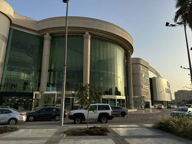Traffic of cars in front of the entrance of the Beach Mall in Dammam, Eastern Province, Saudi Arabia, a comprehensive commercial and entertainment center, diverse restaurants and cafes, recreational areas for children and families, seasonal events and marketing activities, local and international stores and brands, a family-friendly atmosphere for all categories. Traffic of cars in front of the entrance of the Beach Mall in Dammam, Eastern Province, Saudi Arabia, a comprehensive commercial and entertainment center, diverse restaurants and cafes, recreational areas for children and families, seasonal events and marketing activities, local and international stores and brands, a family-friendly atmosphere for all categories.