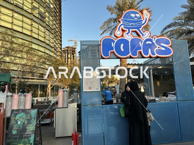 تجمع الزوار في سوق جذور في حديقة الأمير سعود بمدينة الظهران، المنطقة الشرقية، المملكة العربية السعودية، سوق مجتمعي مفتوح يدعم المشاريع المحلية، منتجات حرفية وأطعمة منزلية، أركان تسوق خارجية ، فعاليات عائلية وأنشطة ترفيهية، أجواء تراثية واجتماعية نابضة بالحياة