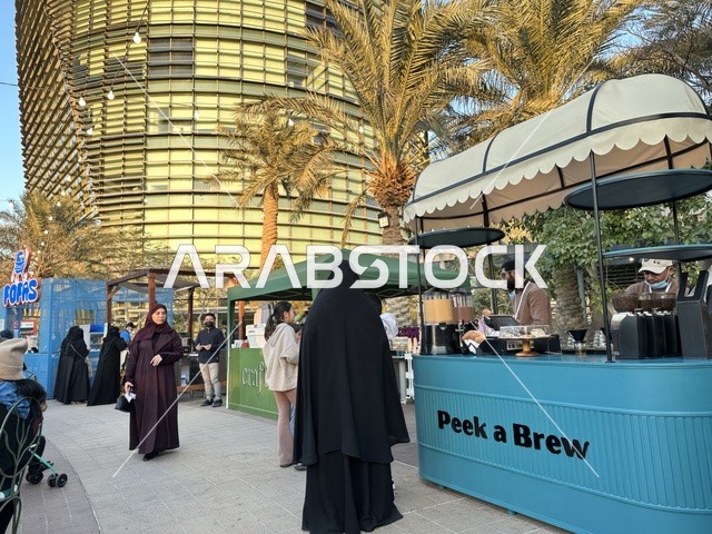 تجمع الزوار في سوق جذور في حديقة الأمير سعود بمدينة الظهران، المنطقة الشرقية، المملكة العربية السعودية، سوق مجتمعي مفتوح يدعم المشاريع المحلية، منتجات حرفية وأطعمة منزلية، أركان تسوق خارجية ، فعاليات عائلية وأنشطة ترفيهية، أجواء تراثية واجتماعية نابضة بالحياة