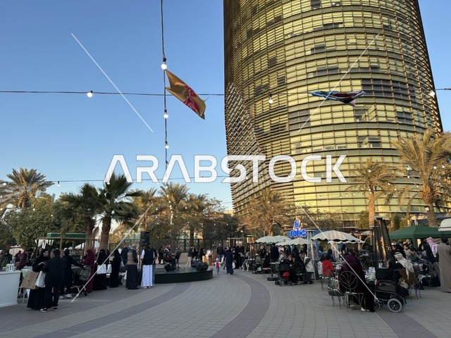 تجمع الزوار في سوق جذور في حديقة الأمير سعود بمدينة الظهران، المنطقة الشرقية، المملكة العربية السعودية، سوق مجتمعي مفتوح يدعم المشاريع المحلية، منتجات حرفية وأطعمة منزلية، أركان تسوق خارجية ، فعاليات عائلية وأنشطة ترفيهية، أجواء تراثية واجتماعية نابضة بالحياة
