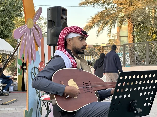 عرض موسيقي حي في سوق جذور في حديقة الأمير سعود بمدينة الظهران، المنطقة الشرقية، المملكة العربية السعودية، سوق مجتمعي مفتوح يدعم المشاريع المحلية، منتجات حرفية وأطعمة منزلية، أركان تسوق خارجية ، فعاليات عائلية وأنشطة ترفيهية، أجواء تراثية واجتماعية نابضة بالحياة