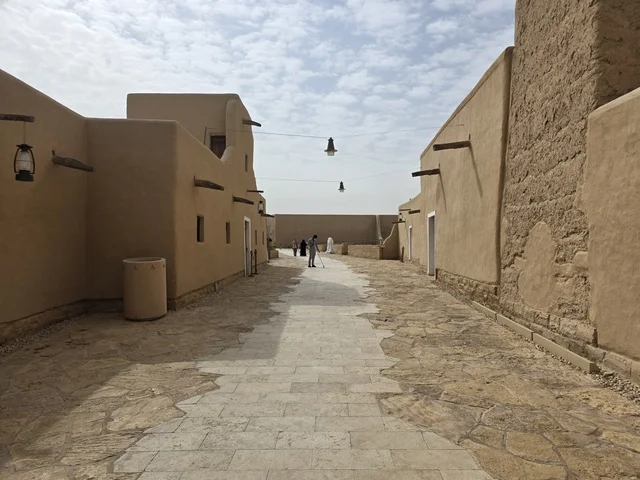 أماكن ترفيهية أثرية في وقت النهار، أشجار النخيل الخضراء، أسوار الدرعية القديمة في مدينة الرياض في المملكة العربية السعودية، معالم أثرية تاريخية قديمة، الفن الهندسي المعماري القديم، صورة للمباني الأثرية والبيوت الطينية في حي الطريف في الدرعية