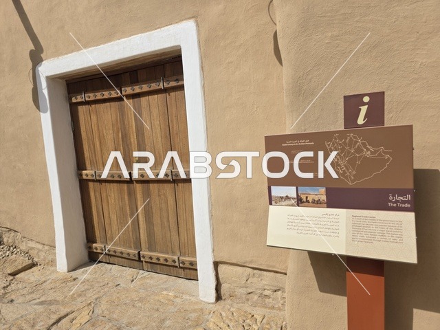 باب الخول لاحدى البيوت الطينية، أشجار النخيل الخضراء، أسوار الدرعية القديمة في مدينة الرياض في المملكة العربية السعودية، معالم أثرية تاريخية قديمة، الفن الهندسي المعماري القديم، صورة للمباني الأثرية والبيوت الطينية في حي الطريف في الدرعية