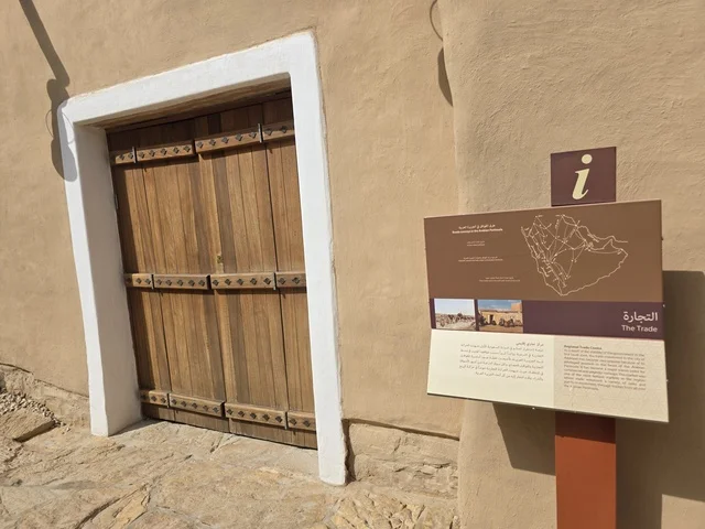 باب الخول لاحدى البيوت الطينية، أشجار النخيل الخضراء، أسوار الدرعية القديمة في مدينة الرياض في المملكة العربية السعودية، معالم أثرية تاريخية قديمة، الفن الهندسي المعماري القديم، صورة للمباني الأثرية والبيوت الطينية في حي الطريف في الدرعية