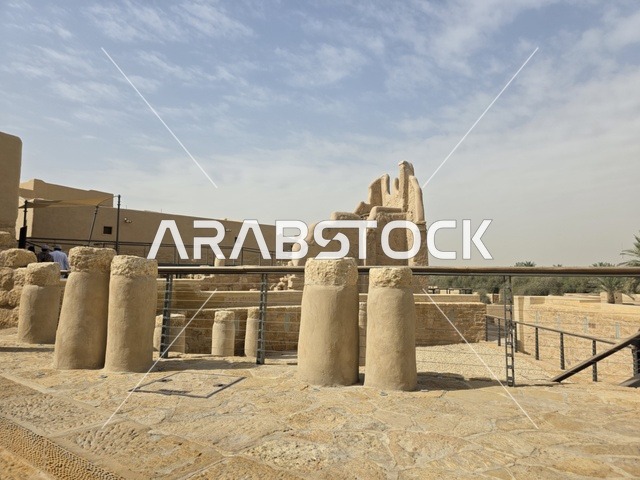 أماكن ترفيهية أثرية في وقت النهار، أشجار النخيل الخضراء، أسوار الدرعية القديمة في مدينة الرياض في المملكة العربية السعودية، معالم أثرية تاريخية قديمة، الفن الهندسي المعماري القديم، صورة للمباني الأثرية والبيوت الطينية في حي الطريف في الدرعية