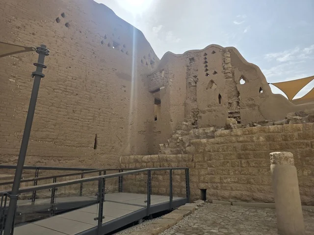 The old houses in Diriyah, the green palm trees, the ancient walls of Diriyah in Riyadh, Saudi Arabia, ancient historical archaeological landmarks, the art of ancient architectural engineering, a picture of the archaeological buildings and mud houses in the Al-Turaif neighborhood in Diriyah, heritage tourism areas in Saudi Arabia.