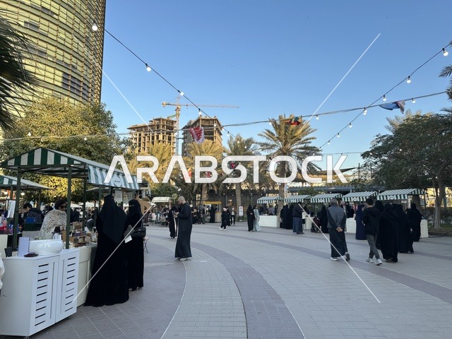 تجمع الزوار في سوق جذور في حديقة الأمير سعود بمدينة الظهران، المنطقة الشرقية، المملكة العربية السعودية، منتجات حرفية وأطعمة منزلية، أركان تسوق خارجية ، فعاليات عائلية وأنشطة ترفيهية،  سوق مجتمعي مفتوح يدعم المشاريع المحلية، أجواء تراثية واجتماعية نابضة بالحياة